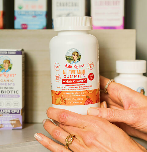Hands holding a bottle of MaryRuth's Multivitamin Gummies.