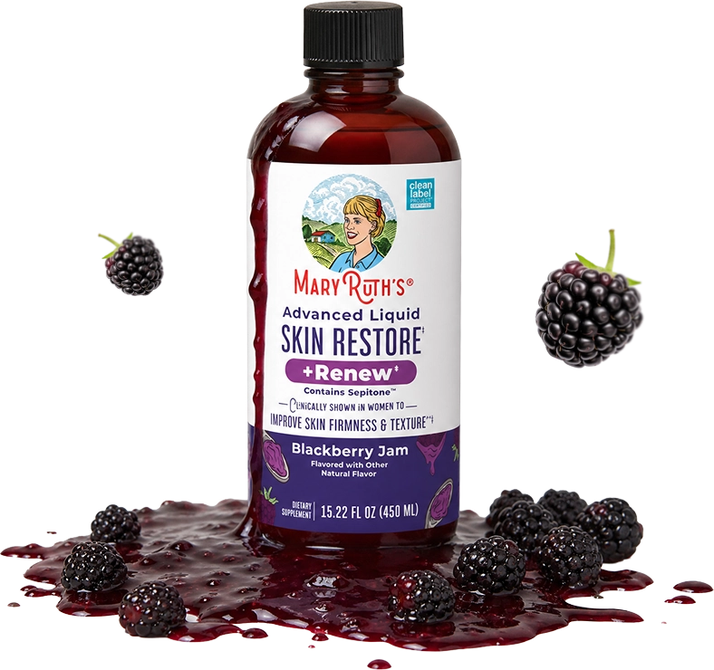 A bottle of Mary Ruth's liquid skin supplement surrounded by spilled blackberry jam and fresh blackberries.