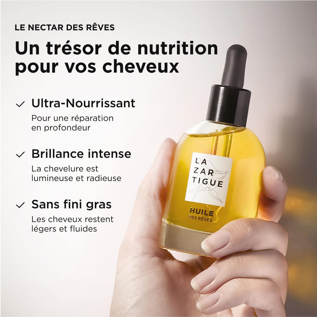 Hand holding a bottle of hair oil with French text on the side.