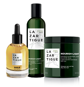 Three hair care products with 'Lazartigue' labels, including oil, shampoo, and a mask.