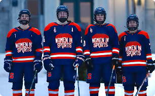 Four hockey players in blue uniforms with 'Women in Sports' text, standing on ice.