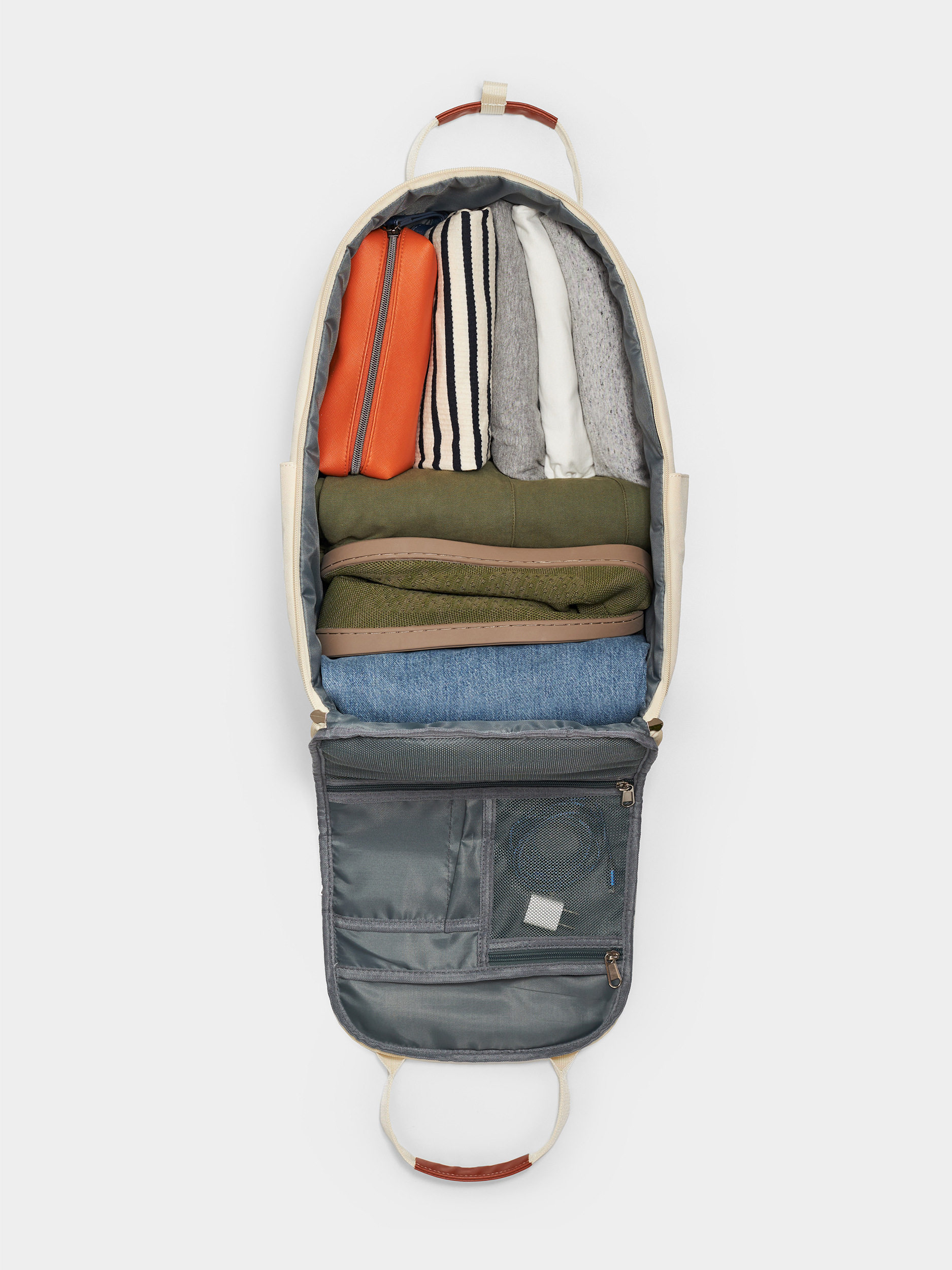 Open backpack displaying neatly packed clothes and a zippered compartment.