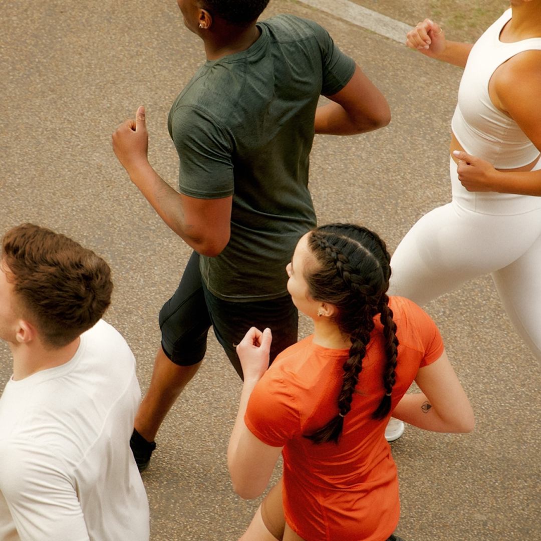 Group of people jogging on a paved path.