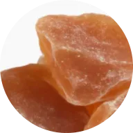 A close-up, circular image of several amber-colored, crystallized chunks of what appears to be dried fruit.