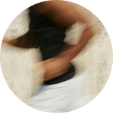Blurred image of a person running against a neutral background.