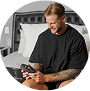 Person sitting on a bed, holding a gaming controller, smiling.