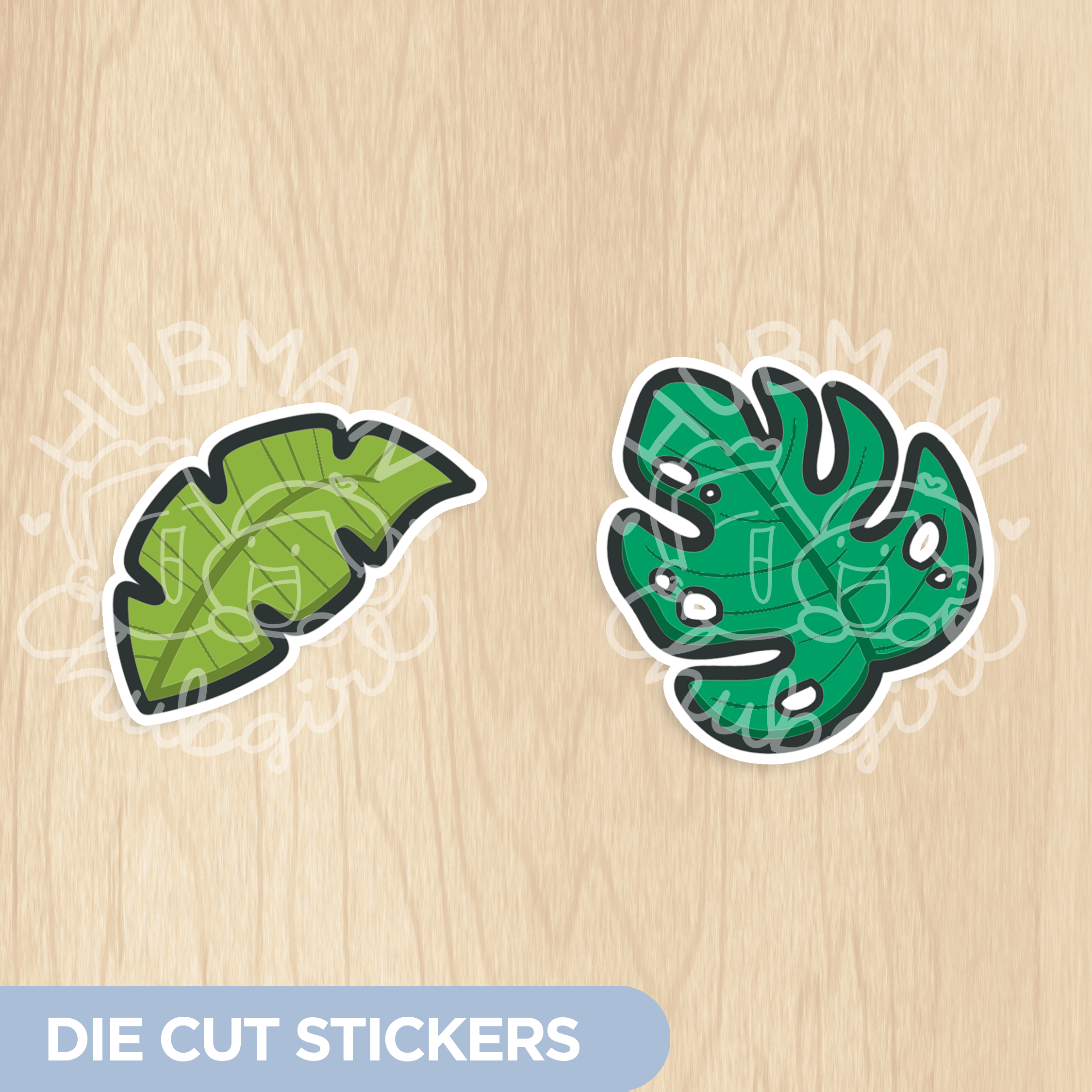 Two die-cut stickers, one of a banana leaf and one of a monstera leaf, on a wood background.