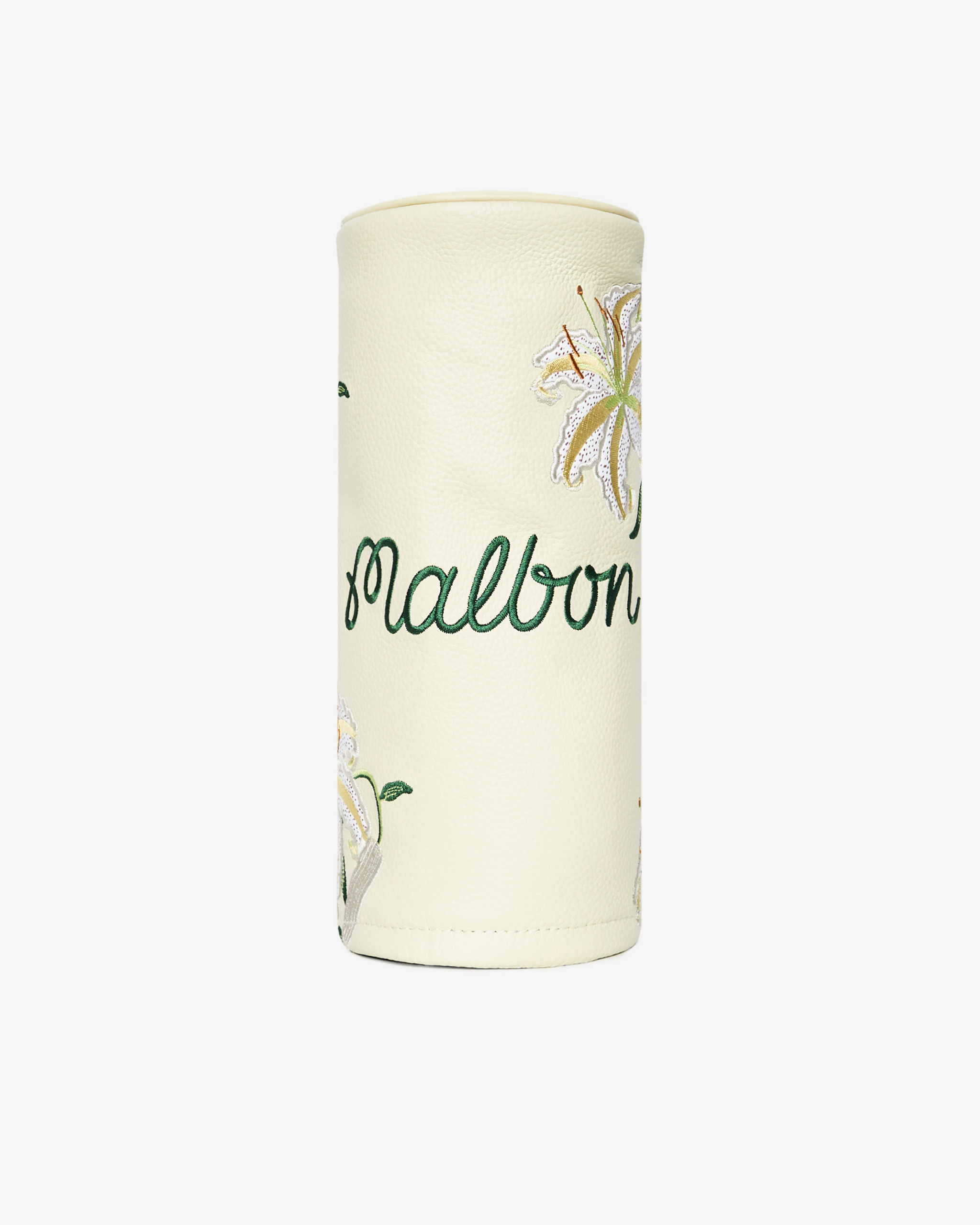 A cream-colored leather golf headcover embroidered with the name Malbon in green script and lily flowers.