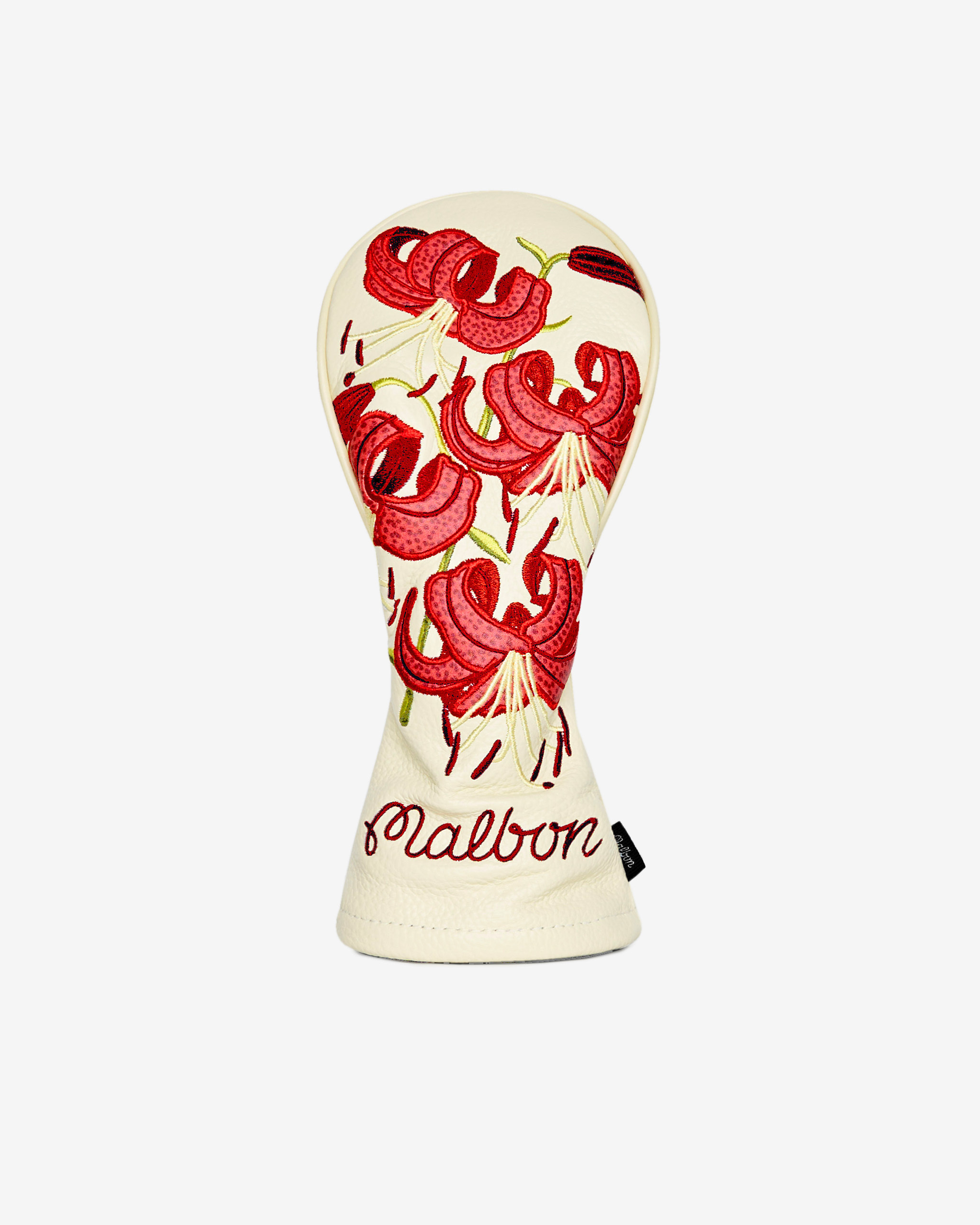 An off-white Malbon golf headcover with embroidered red lily flowers, shot against a white background.