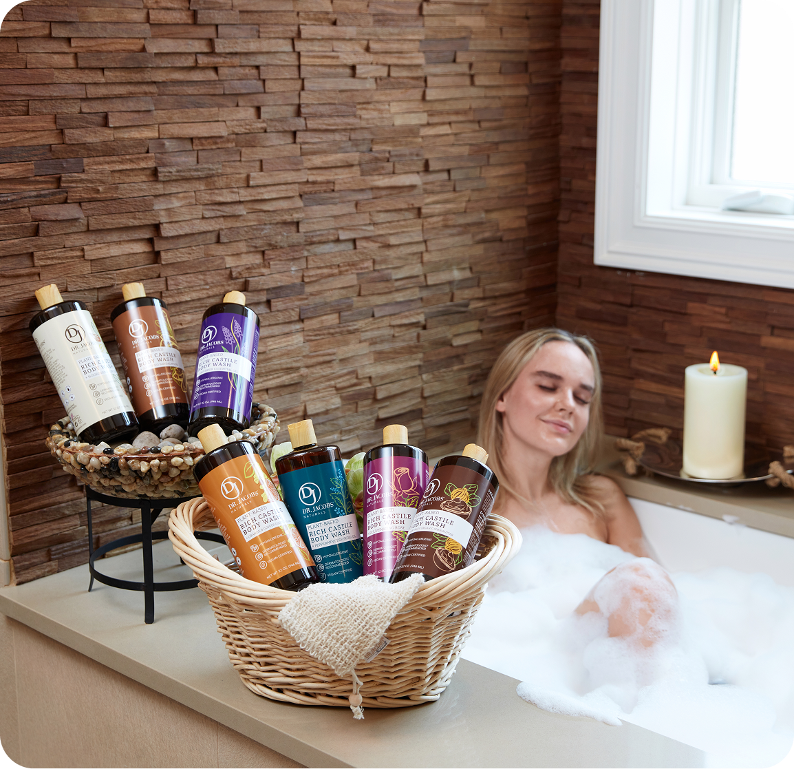 A woman relaxes in a bubble bath next to baskets filled with Dr. Jacobs Naturals body wash.