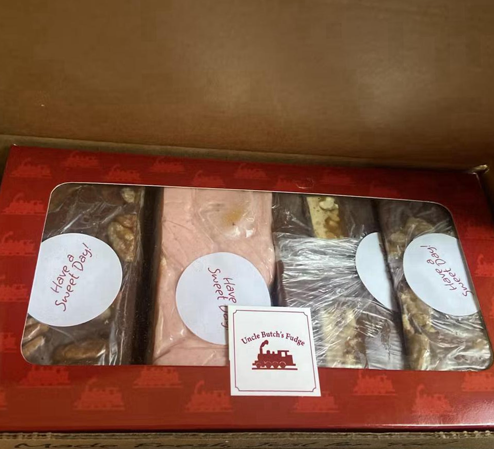 Box of assorted fudge with 'Have a Sweet Day' stickers.