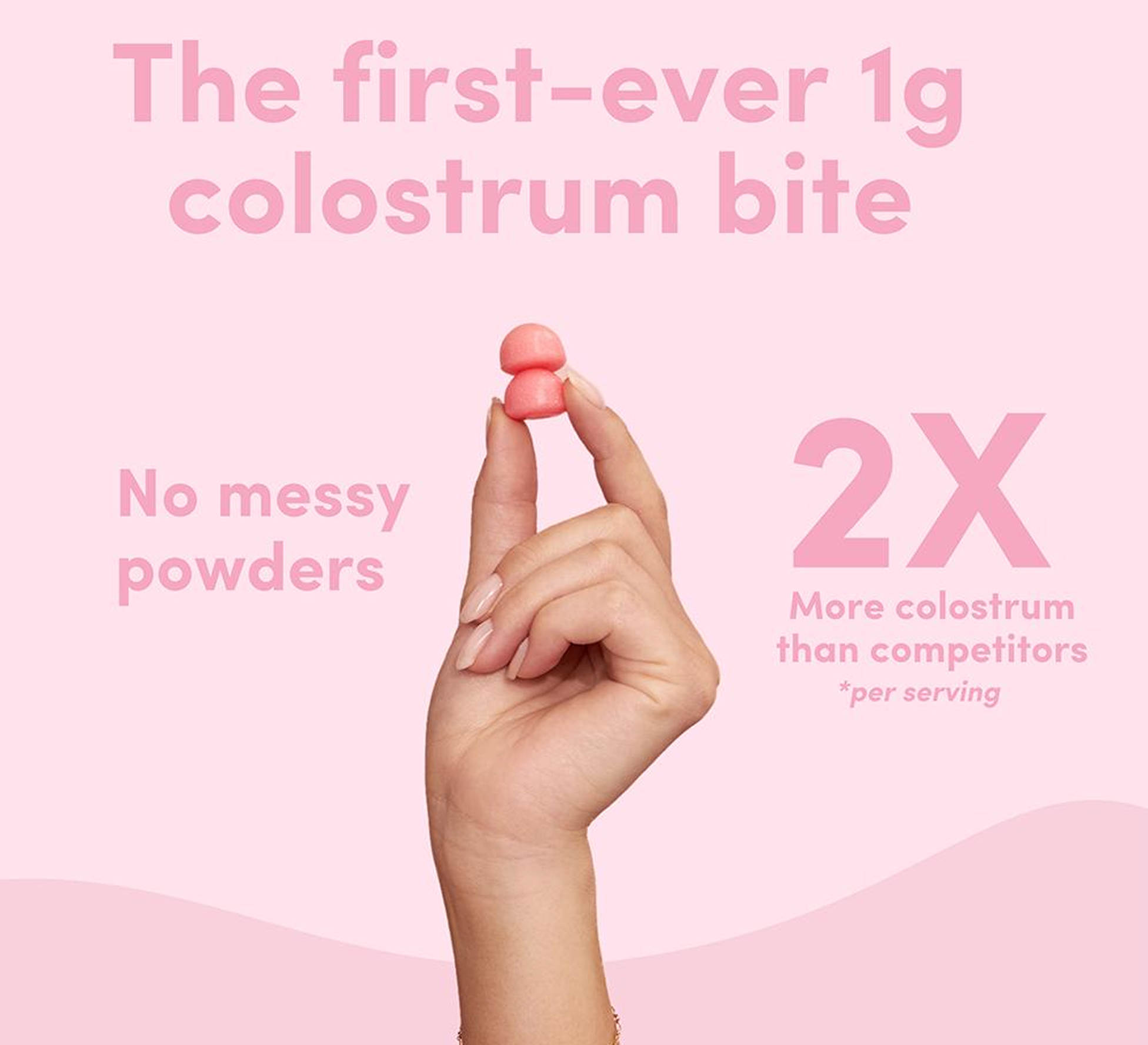 Hand holding a pink colostrum bite with promotional text on pink background.