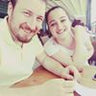 Two people smiling at a table, indoors.