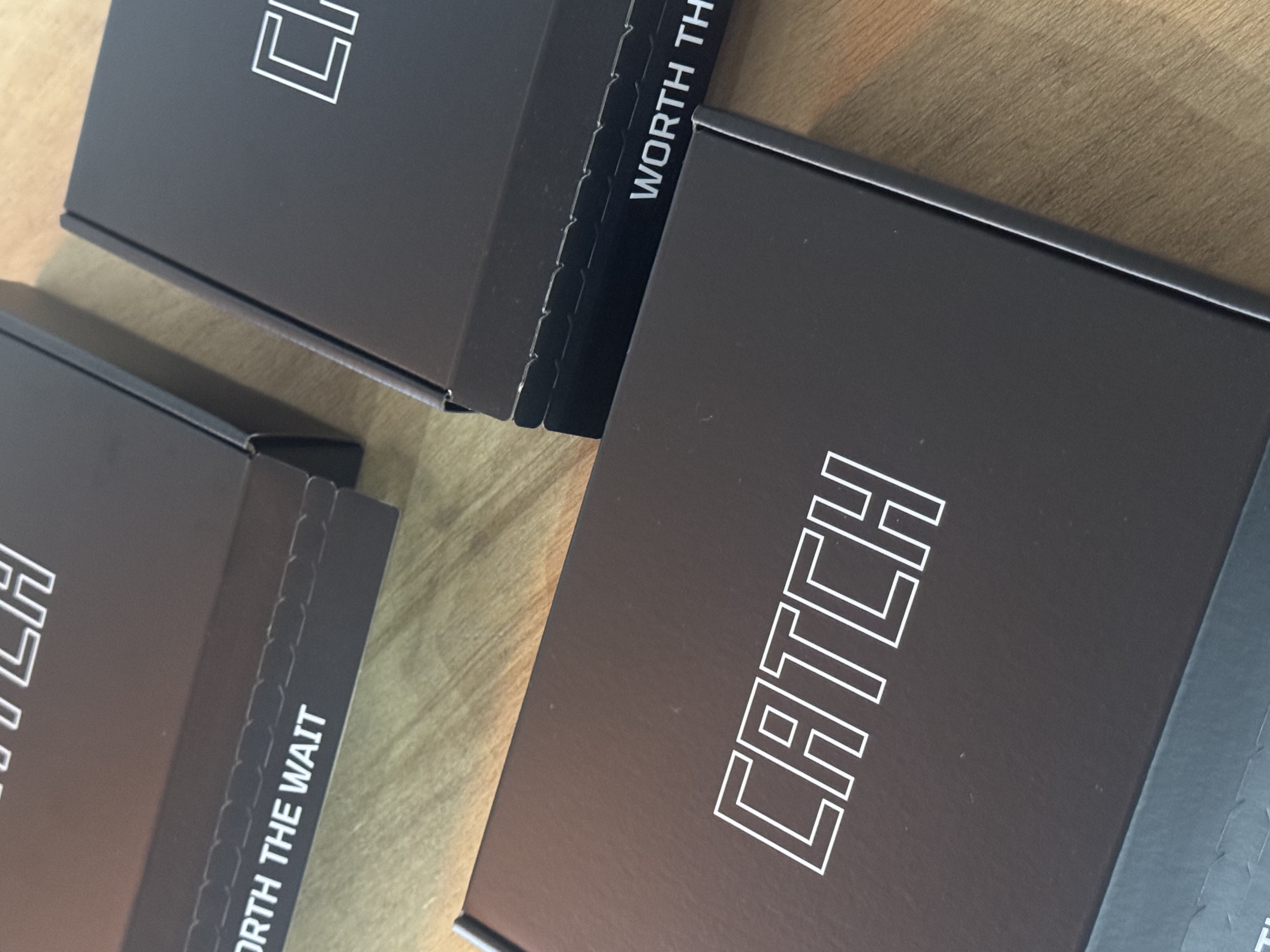 Dark boxes labeled 'CATCH' on a wooden surface.