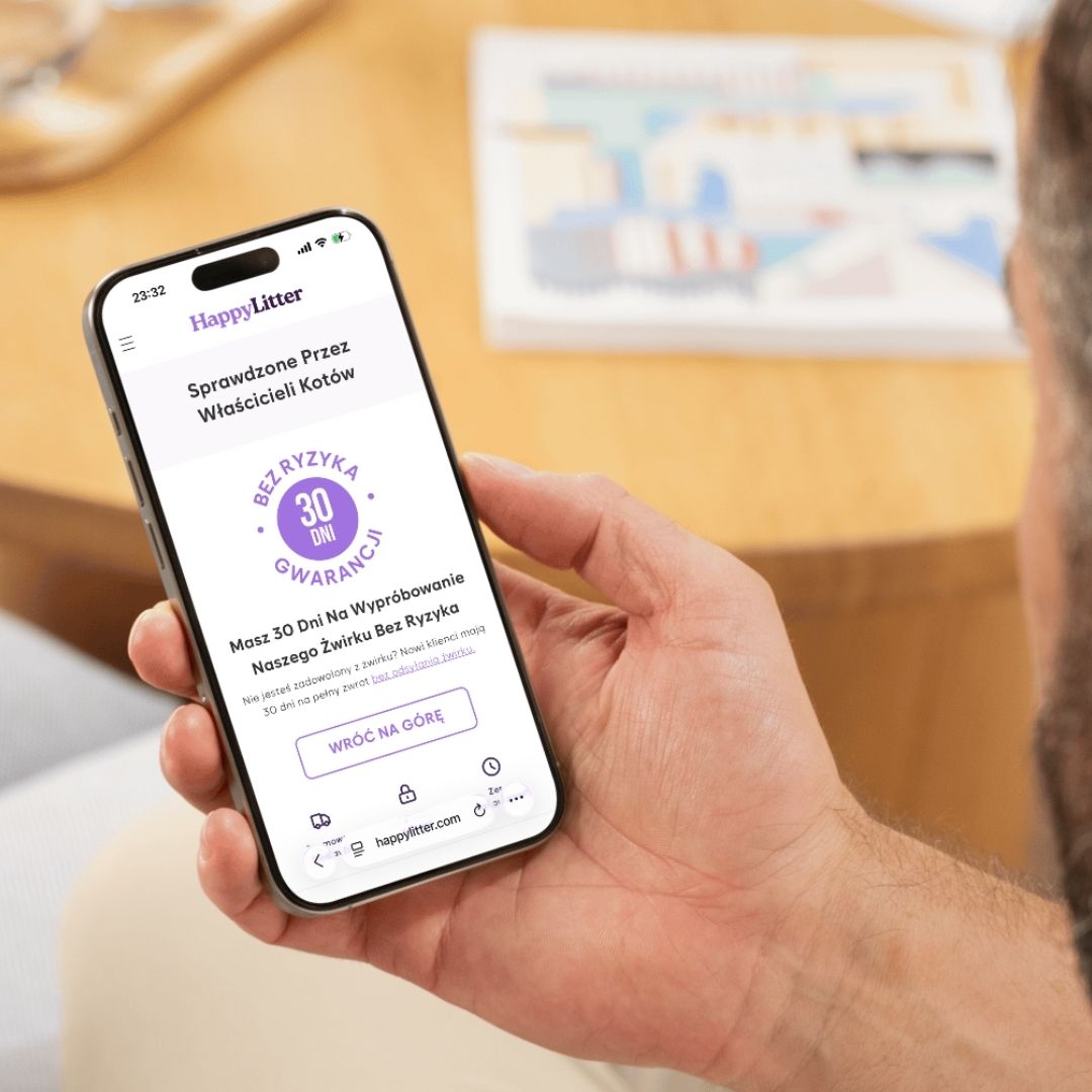 Person holding a smartphone showing a webpage with a purple guarantee badge.