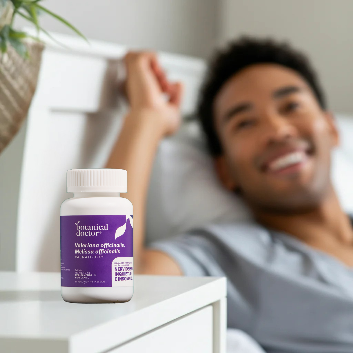 Bottle of supplement on a table with a smiling person in the background.