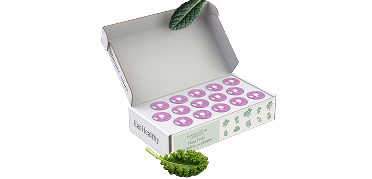 An open white box of plant pods with purple tops, decorated with two leaves of kale.