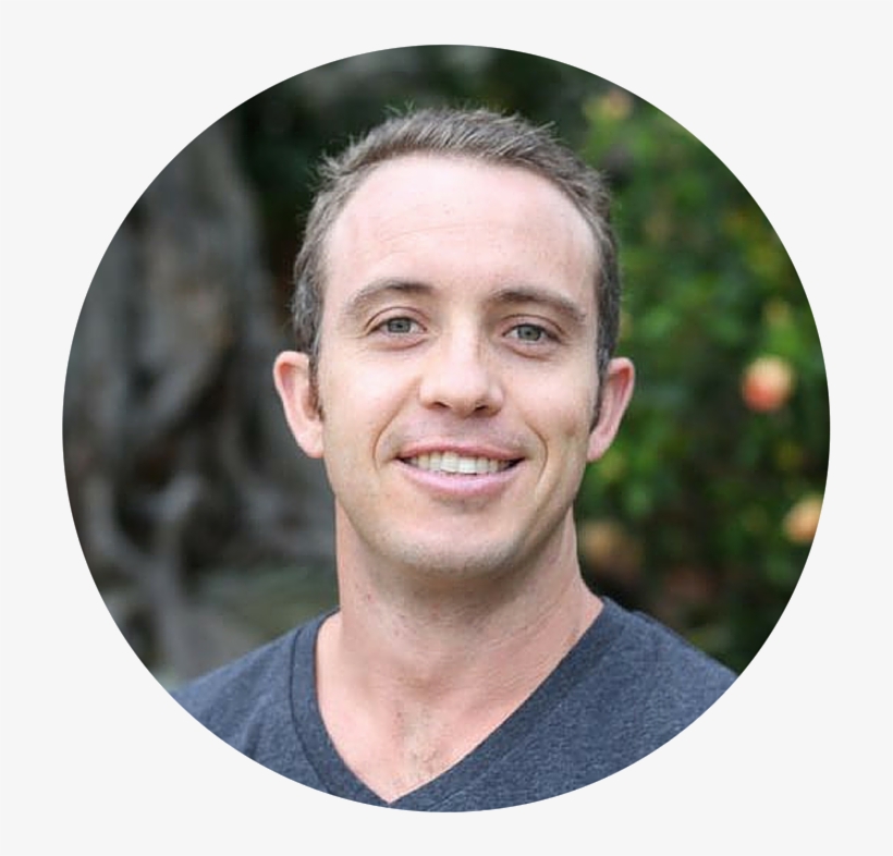Man smiling with greenery in the background.
