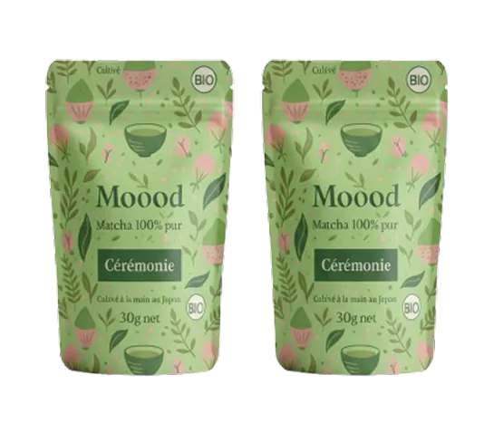 Two green pouches of Möood matcha tea with floral design.