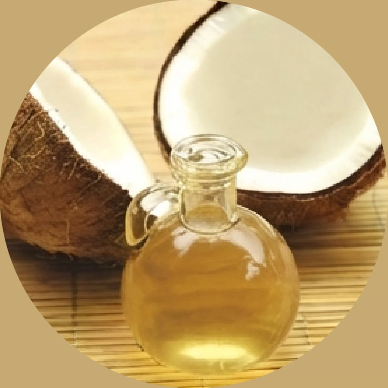 A small glass bottle of oil sits in front of a split coconut on a bamboo mat.