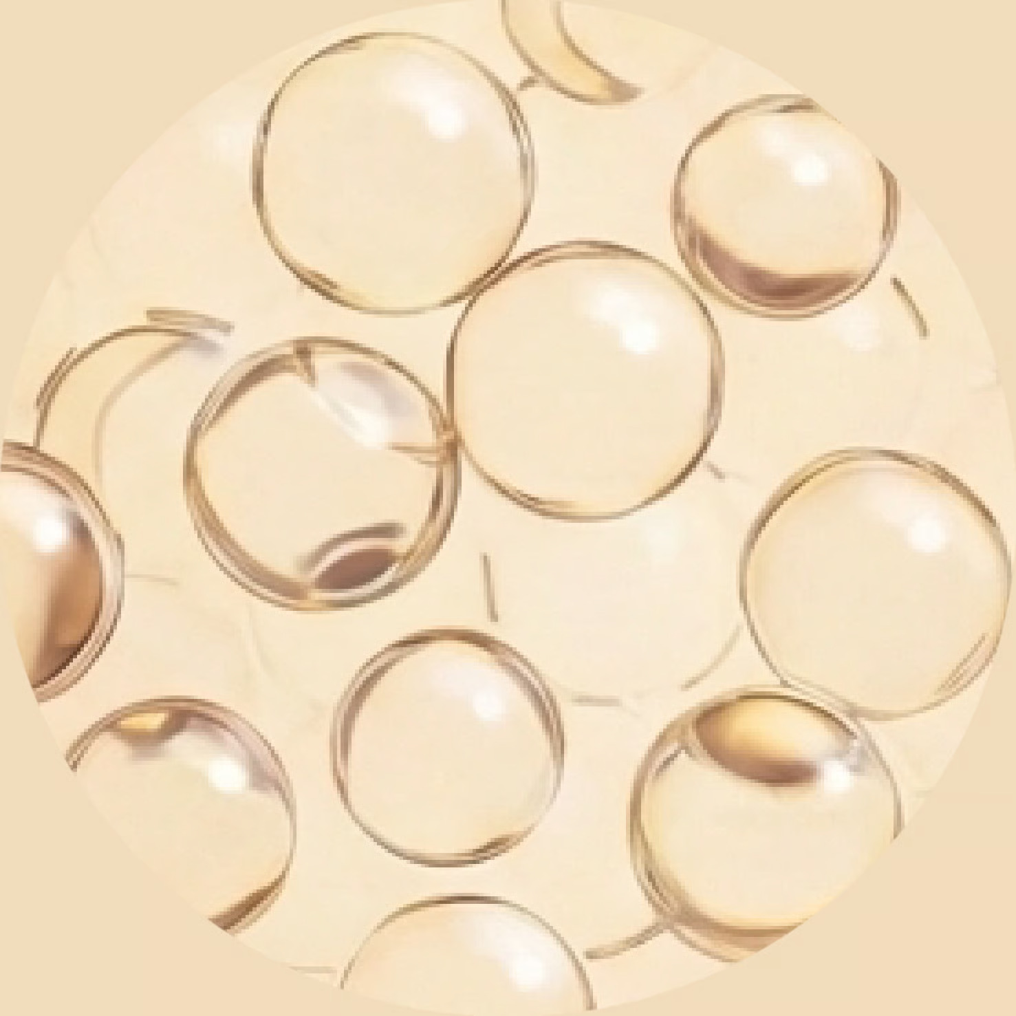 A close-up circular view of many translucent golden spheres against a light beige background.