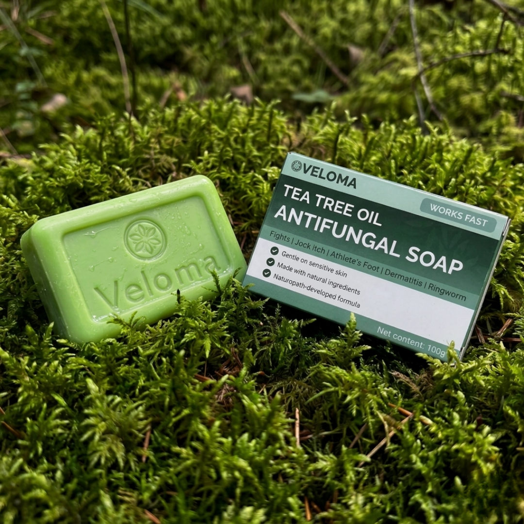 A bar of Veloma Tea Tree Oil Antifungal Soap and its box resting on a bed of moss.