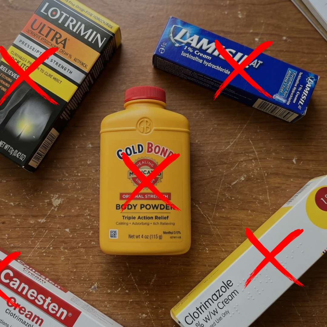 Several antifungal creams and a body powder on a wooden surface, each crossed out with a red X.