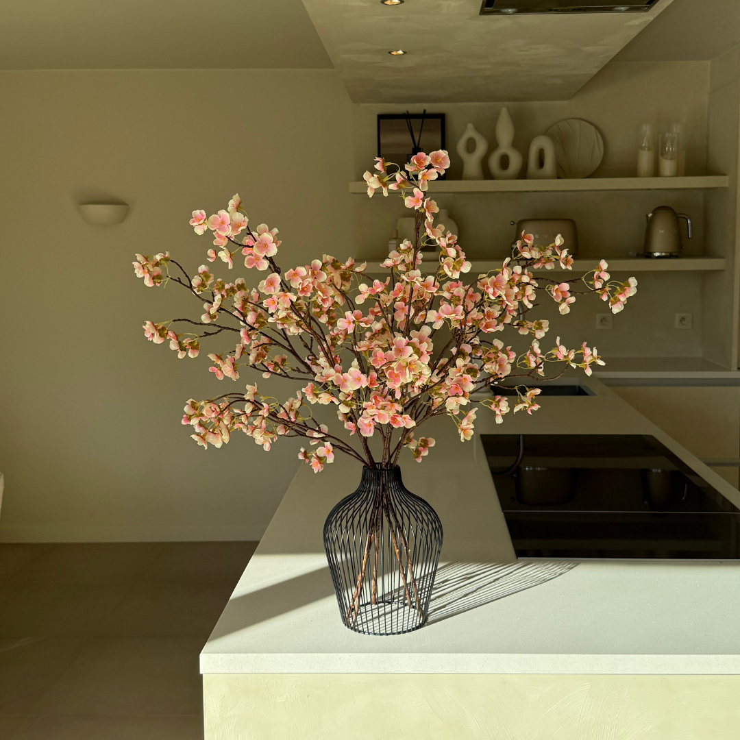 Vase with pink flowers on a kitchen countertop in a modern interior.