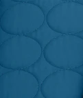 A close-up of a teal-blue quilted fabric with an oval stitch pattern.