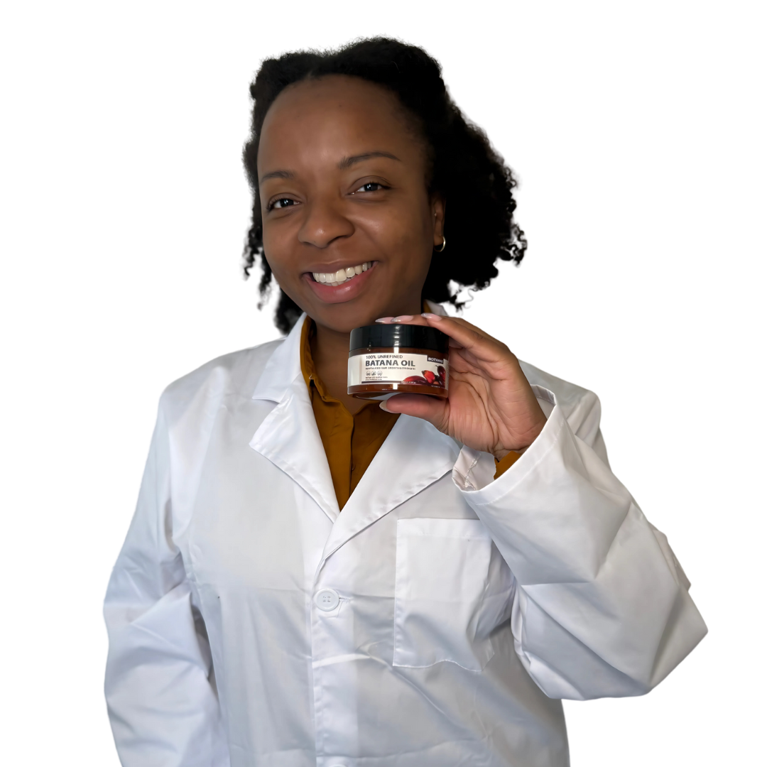Person in lab coat holding a jar of Batana Oil, smiling.