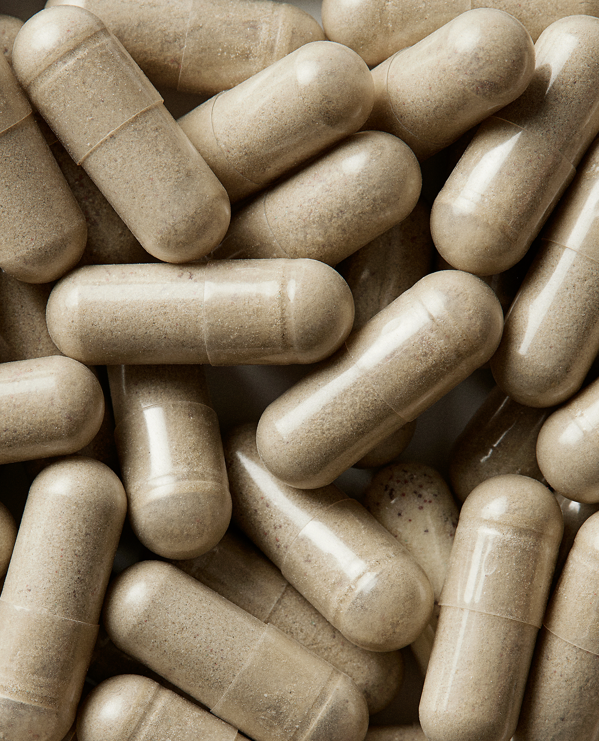 Close-up of beige capsules filled with powder.