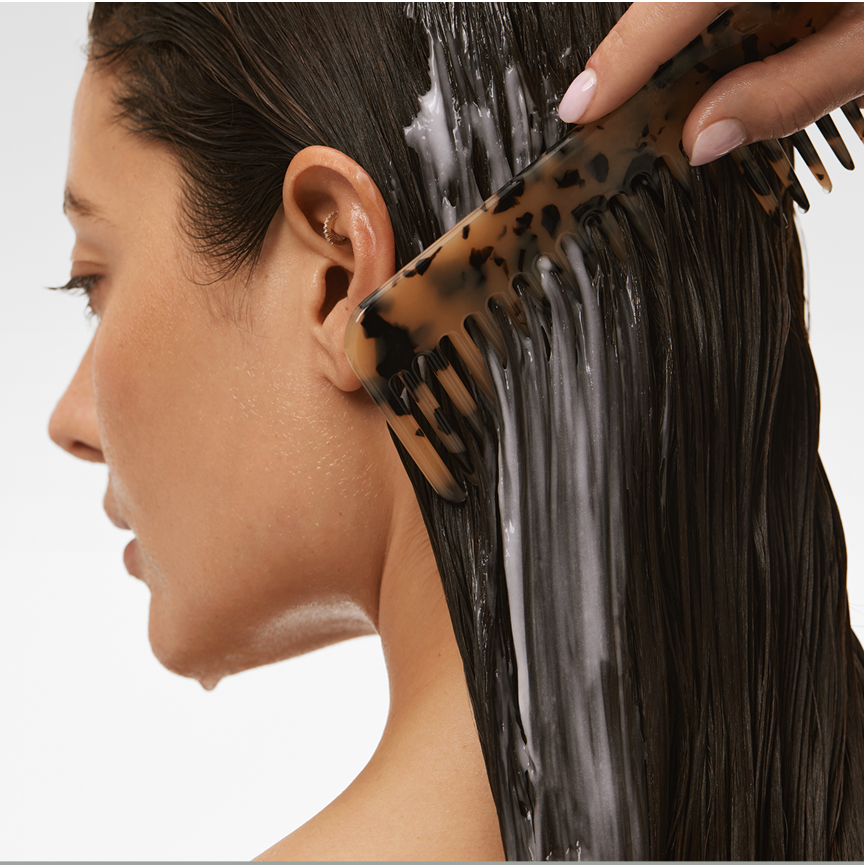 Person combing wet hair with a tortoiseshell comb.