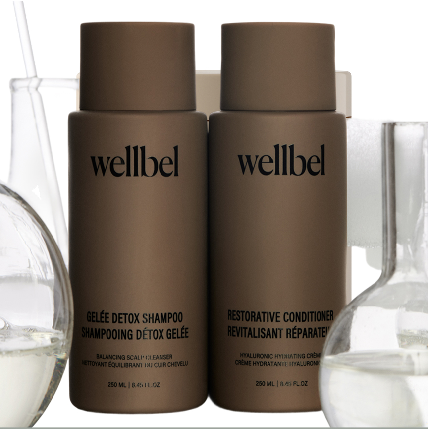 Two brown bottles labeled 'wellbel' with laboratory glassware in the background.