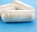 Close-up of white capsules on a blue background.