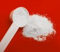 White powder and scoop on a red background.