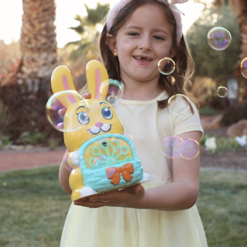 Child holding a yellow bunny toy with bubbles floating around.