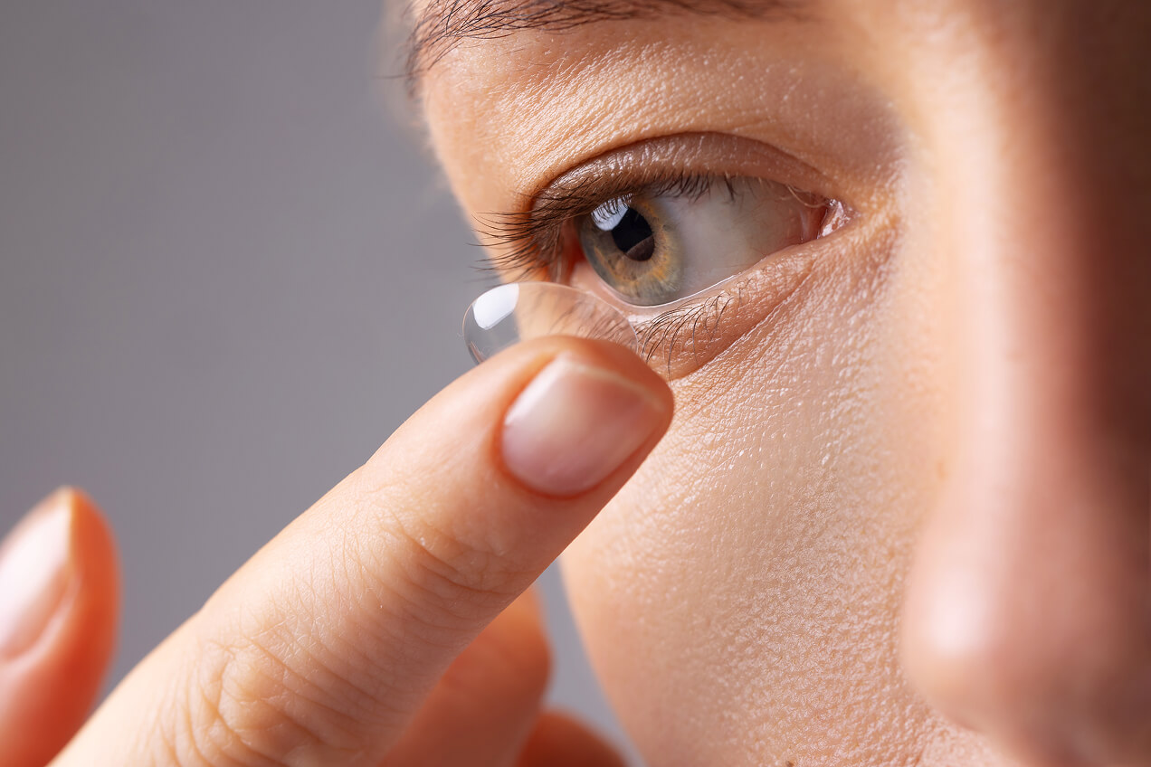 Woman putting on contact lenses