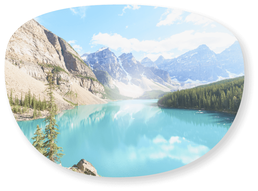 Image ovale d’un lac turquoise entouré de hautes montagnes rocheuses aux sommets enneigés et de conifères.
