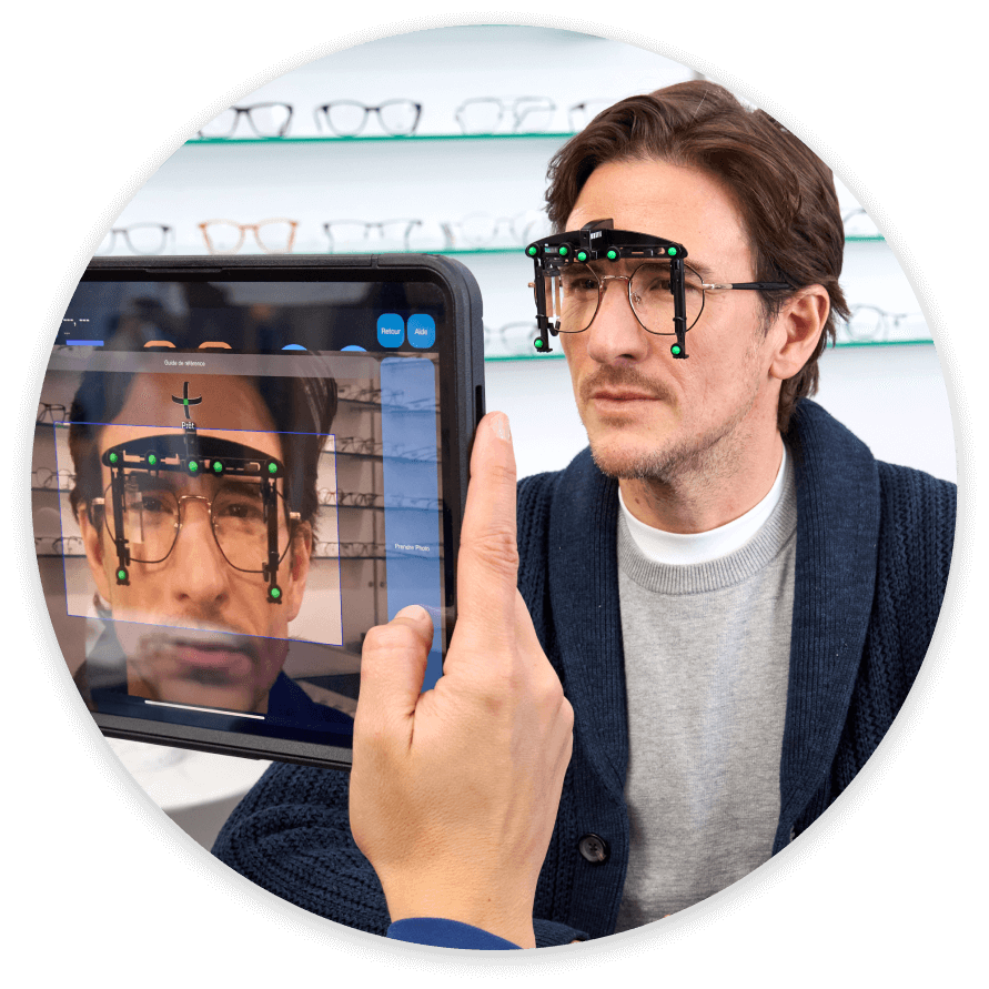 An optician uses a tablet and a special device to take digital measurements for a man's new glasses.