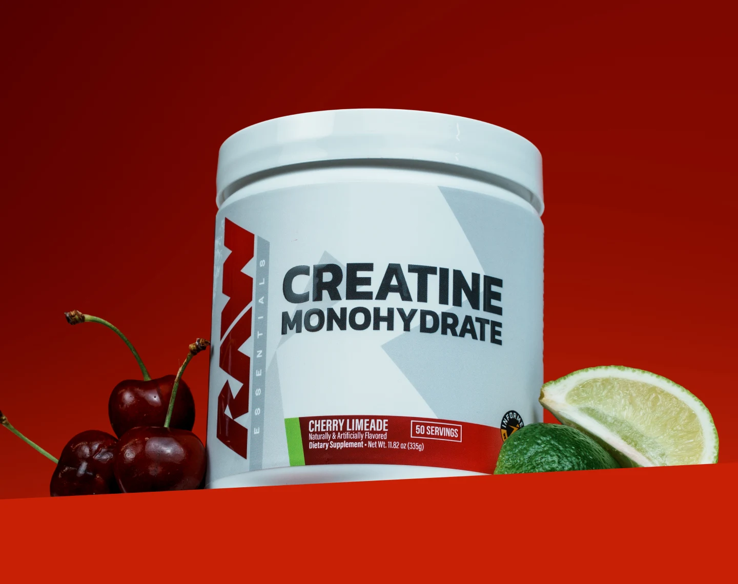A tub of Raw Essentials Cherry Limeade Creatine Monohydrate next to fresh cherries and a sliced lime.