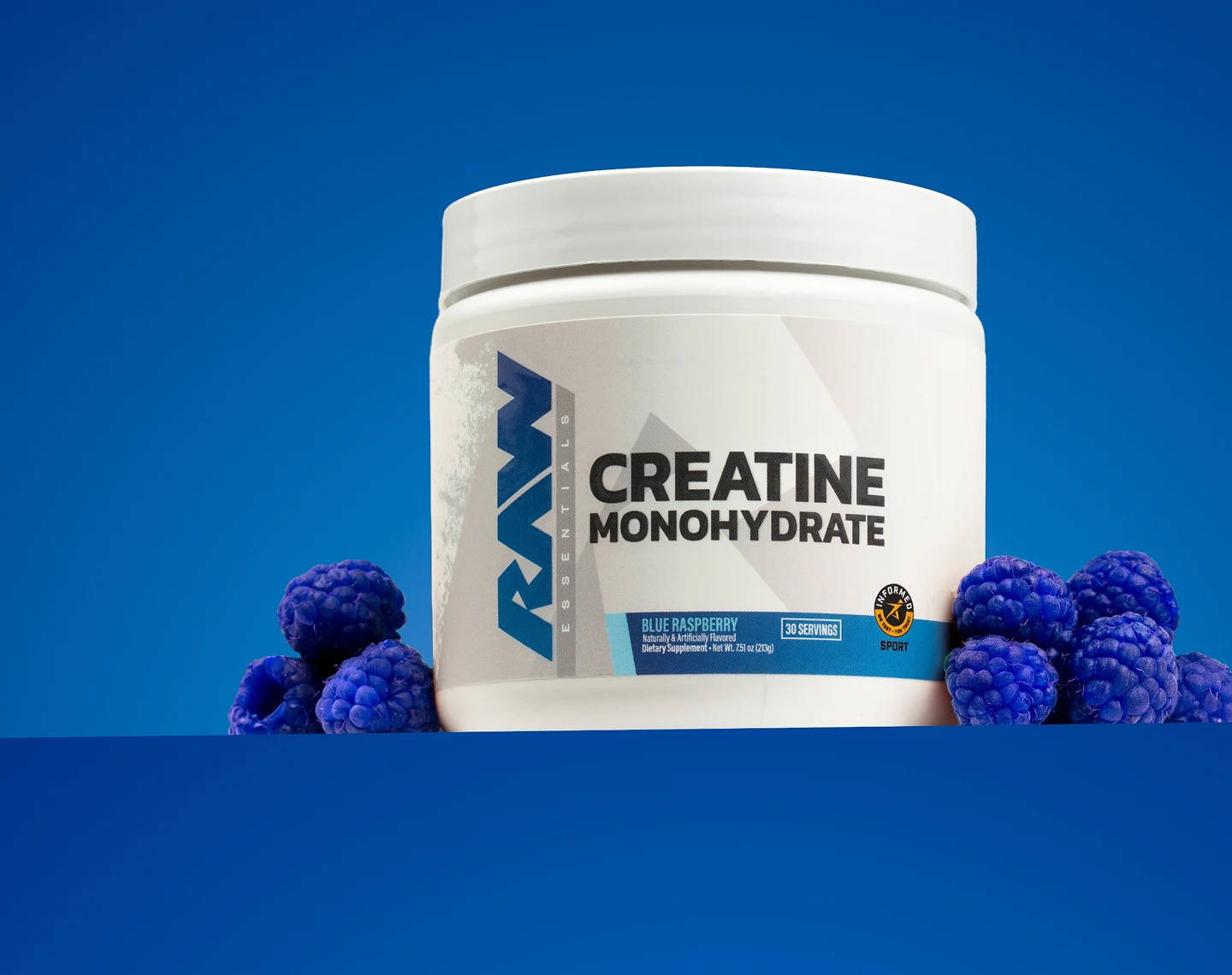 A white tub of RAW Blue Raspberry Creatine Monohydrate surrounded by blue raspberries on a blue background.
