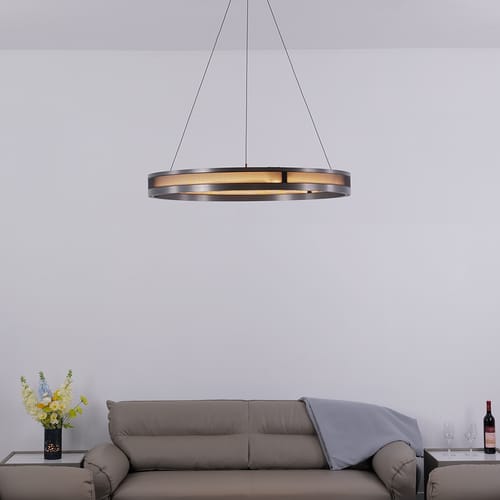 Modern wall sconce with gold accents beside a beige upholstered headboard.