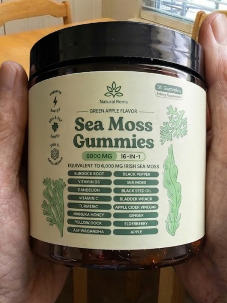 A person's hands holding a jar of Natural Rems Sea Moss Gummies with a green apple flavor label.