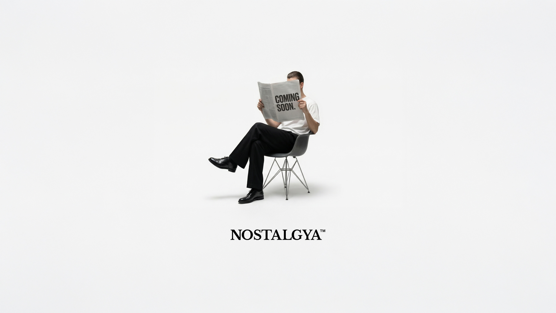 A person sits on a chair reading a newspaper that says 'COMING SOON.' below the word NOSTALGYA™.