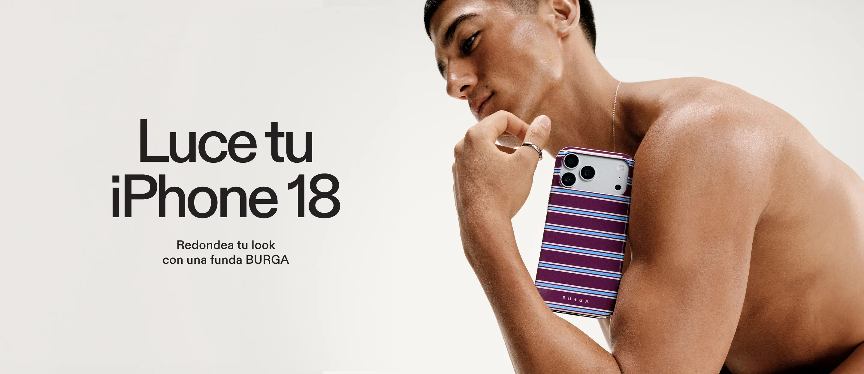 A shirtless man holds up an iPhone with a purple, blue, and white striped case.