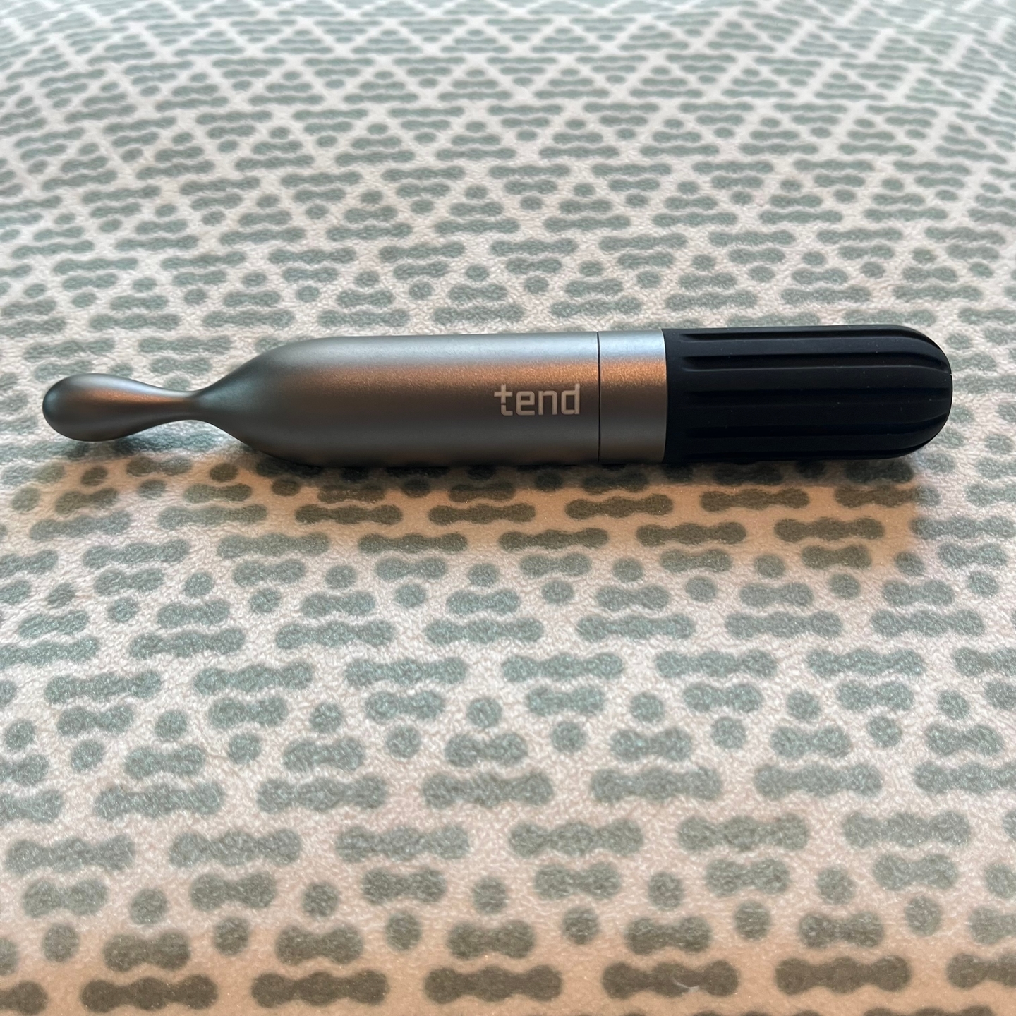 Metallic dental tool on patterned surface.