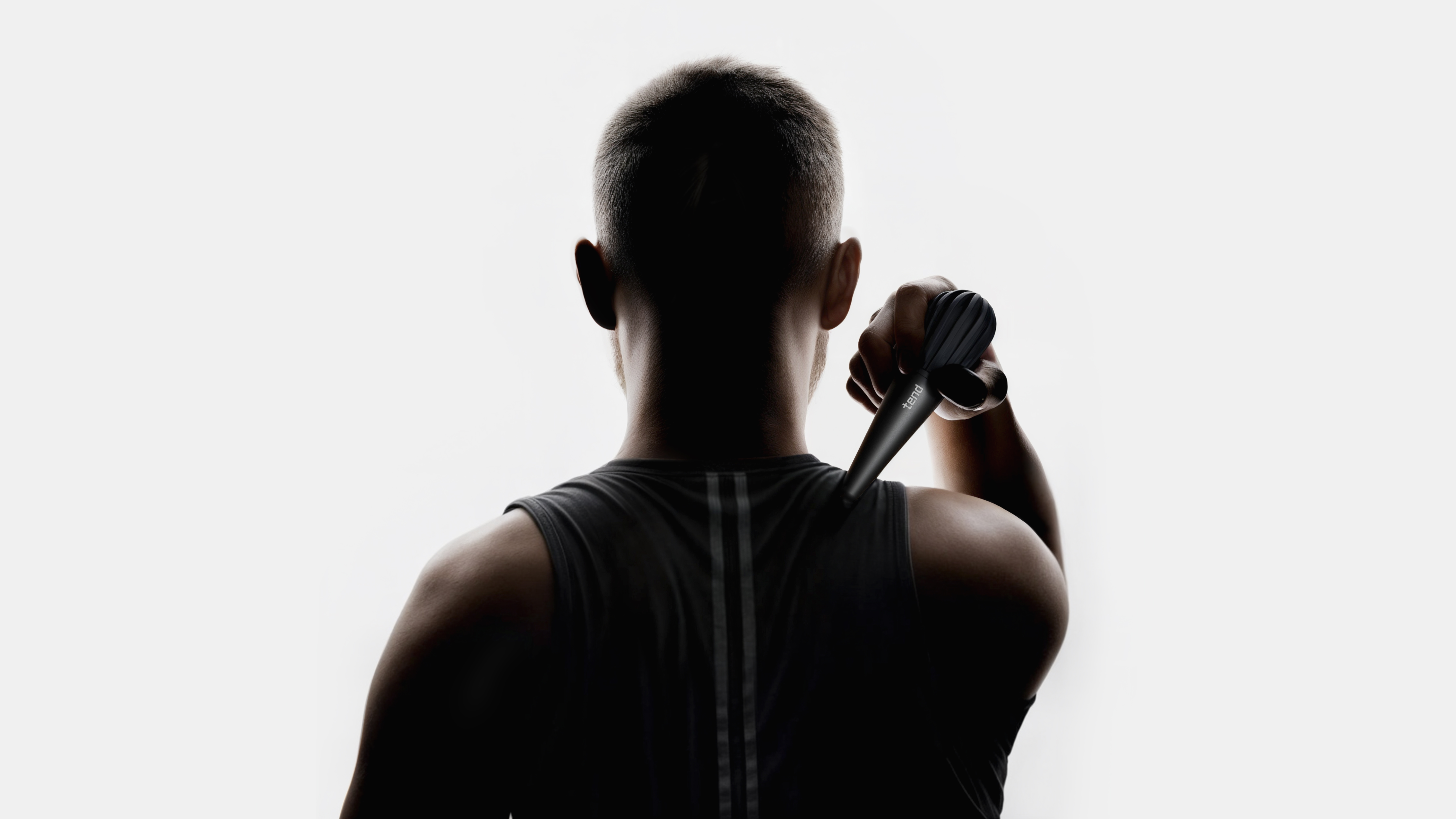 Silhouette of a person using a handheld massager on their back.