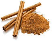 Three cinnamon sticks and a pile of ground cinnamon.