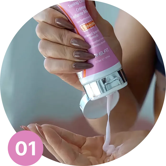 A hand with long, manicured nails squeezes cream from a pink tube into an open palm.