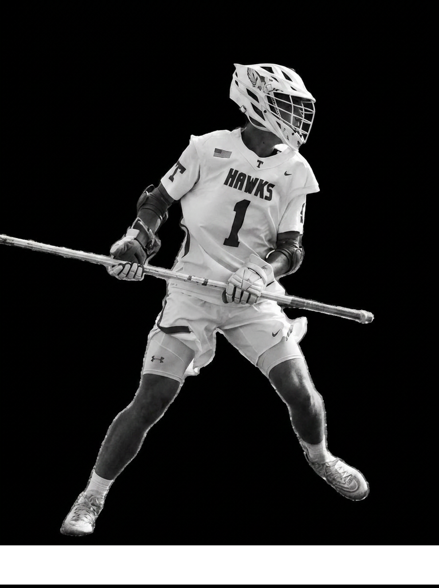 A black and white photo of a lacrosse player in a Hawks jersey holding a stick against a black background.